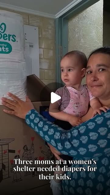 A mother holding a child beside boxes of diapers in an Instagram Reel preview